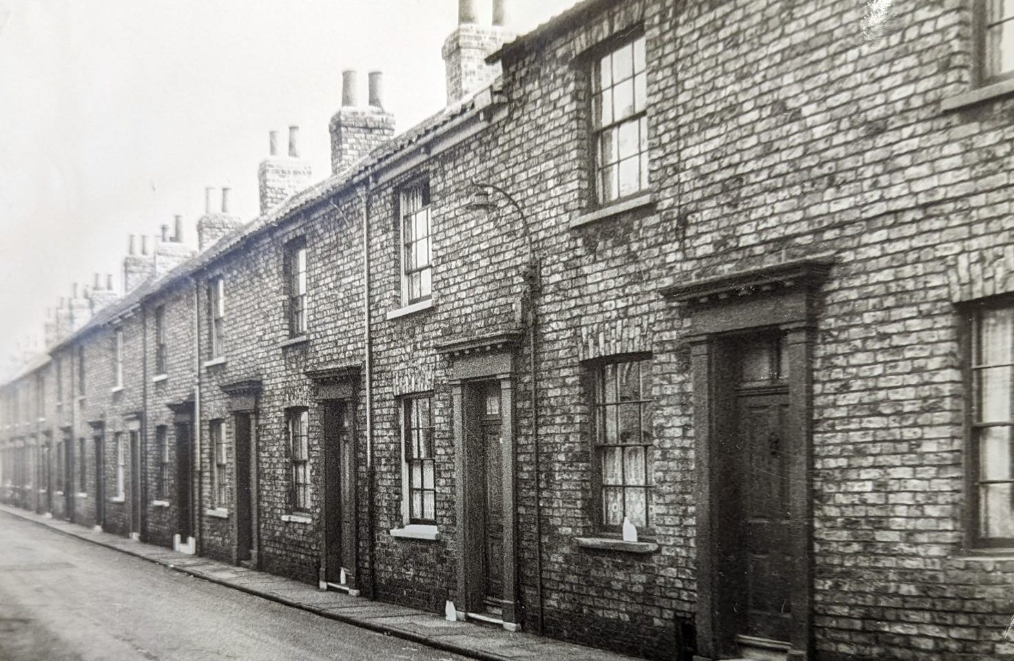 an old photo of a row of terraced houses.